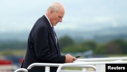 FILE - White House Chief of Staff John Kelly looks down at his phone as he boards Air Force One in Hagerstown, Maryland.