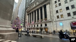 FILE - A scooter passes the New York Stock Exchange in New York's Financial District, Dec. 17, 2024. Stock prices fell Feb. 7, 2025, as investors fretted about inflation and tariffs.