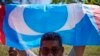 FILE - A supporter of People's Justice Party waves its party flag outside the National Palace in Kuala Lumpur, Malaysia, on Feb. 26, 2020. 