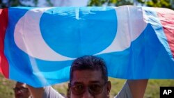 FILE - A supporter of People's Justice Party waves its party flag outside the National Palace in Kuala Lumpur, Malaysia, on Feb. 26, 2020. 