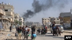 Palestinians cross the main Salaheddine road into Jabalia in the northern Gaza Strip on bicycles and tuk-tuks following Israeli army evacuation orders on Nov. 12, 2024.