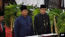 FILE - Presiden Indonesia Prabowo Subianto (kiri), dan Wakil Presiden Gibran Rakabuming Raka dalam upacara pengambilan sumpah di gedung DPR di Jakarta, 20 Oktober 2024. (Tatan Syuflana/AP)