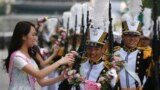 Cadet from the Korea Naval Academy reacts after receiving a garland from the winner of the 2013 Miss Korea Pageant during a parade to mark the 65th anniversary of Korea Armed Forces Day in central Seoul, South Korea. 