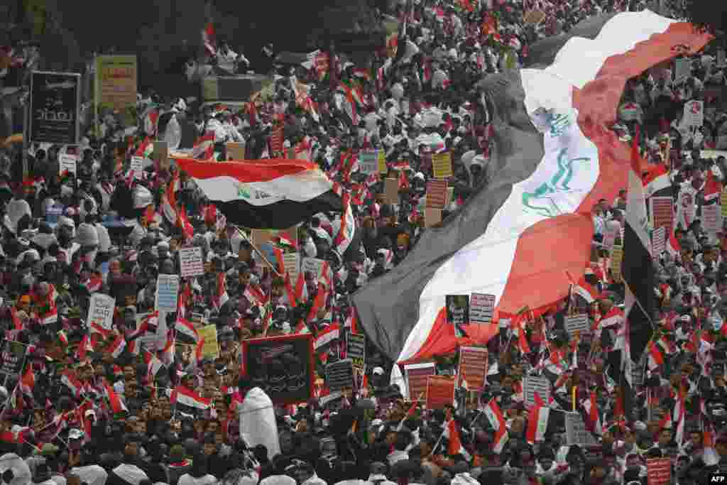 Thousands of Iraqis, waving national flags, take to the streets in central Baghdad to demand the ouster of U.S. troops from the country. 