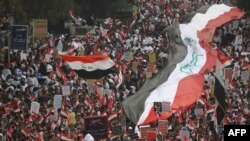 Thousands of Iraqis, waving national flags, take to the streets in central Baghdad on January 24, 2020 to demand the ouster of US troops from the country. 
