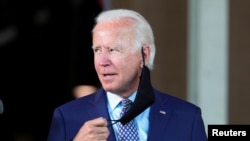 El candidato presidencial demócrata, Joe Biden, se quita su tapabocas durante un acto de campaña en Dunmore, Pensilvania, el 9 de julio de 2020.
