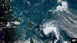 This satellite image provided by the National Oceanic and Atmospheric Administration (NOAA) shows a tropical storm east of Puerto Rico in the Caribbean, at 7:50am EST, Tuesday, Aug. 10, 2021. The National Hurricane Center issued tropical storm…