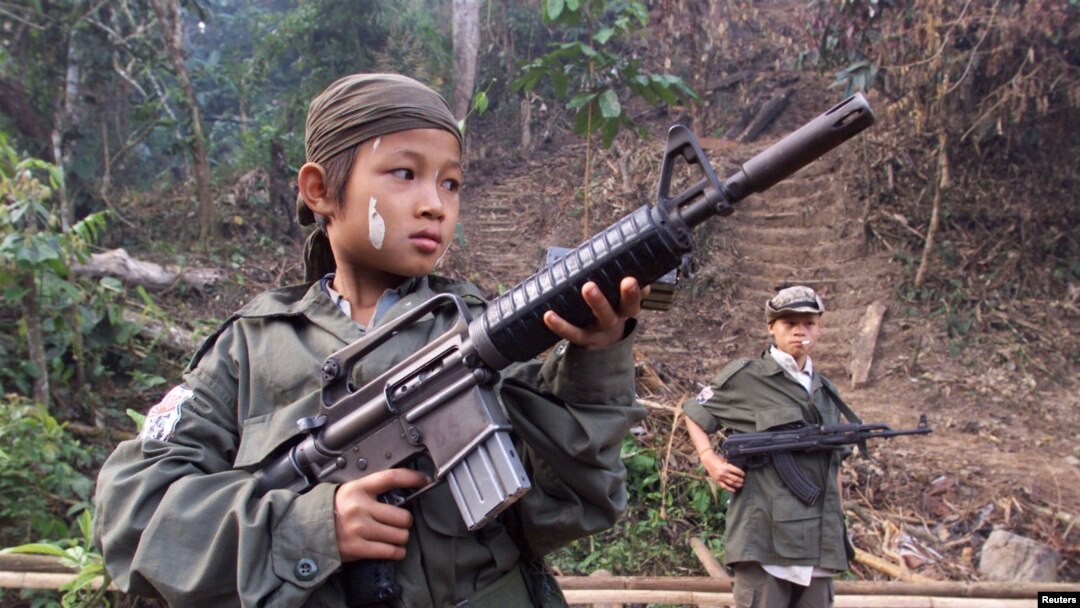Dalam foto dokumentasi yang diambil tahun 2000 ini, nampak Samboo, seorang bocah berusia 12 tahun tengah berpose dengan senapan miliknya di sebuah hutan dekat perbatasan Thailand. Samboo, salah satu dari tentara anak yang direkrut untuk memperkuat barisan pemberontak Karen untuk melawan pemerintahan militer Burma. (File: dok).