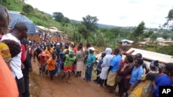 Rescue workers carry a body from the rubble of a landslide in Bafoussam Cameroon, Oct. 29, 2019. 