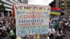 ARCHIVO - Simpatizantes de la oposición protestan contra el presidente Nicolás Maduro con un cartel que dice "Venezuela está herida en el corazón con hambre, miseria, corrupción y dictadura", en Caracas, Venezuela, el 10 de mayo de 2017.