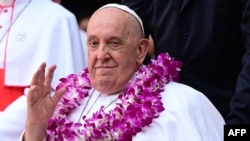 Pope Francis wears a flower garland as he arrives for an interreligious meeting with young people at the Catholic Junior College in Singapore on Sept. 13, 2024. 