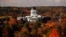 FILE - The State House is surrounded by fall foliage in Augusta, Maine, Oct. 23, 2017. Recent leaf-peeping seasons have been disrupted by weather conditions in New England, New York and elsewhere.