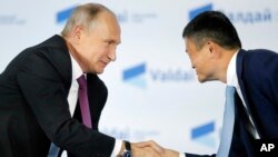 Presiden Vladimir Putin (kiri) berjabat tangan dengan CEO Alibaba, Jack Ma (foto: dok). 