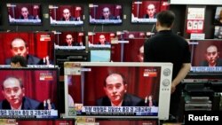 A sales assistant watches TV sets broadcasting a news report on Thae Yong Ho, North Korea's deputy ambassador in London, who has defected with his family to South Korea, in Seoul, South Korea, Aug. 18, 2016. 