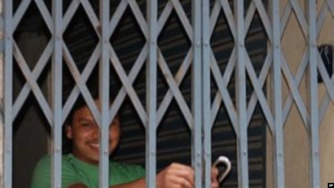 A merchant locking his shop to avoid getting caught violating the Maoist's strike, in Kathmandu, 3 May 2010