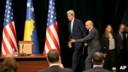 Kosovo Prime Minister Isa Mustafa welcomes U.S. Secretary of State John Kerry to a joint press conference after Kerry's arrival in Kosovo's capital Pristina airport, Dec. 2, 2015. 