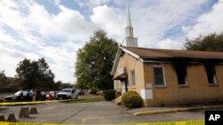 Area residents and church members look on as authorities investigate a fire at Hopewell Baptist Church in Greenville, Mississippi, Nov. 2, 2016. "Vote Trump" was spray-painted on an outside wall of the African American church.