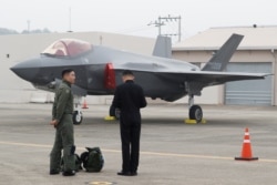A South Korean fighter pilot, left, stands next to his F-35 stealth fighter during a ceremony to mark the 71st Armed Forces Day at the Air Force Base in Daegu, South Korea, Oct. 1, 2019.