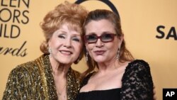 Debbie Reynolds, winner of the Screen Actors Guild lifetime award, left, and Carrie Fisher pose in the press room at the 21st annual Screen Actors Guild Awards at the Shrine Auditorium, Jan. 25, 2015, in Los Angeles. 