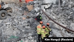 Para petugas penyelamat turut serta dalam operasi evakuasi di lokasi runtuhnya konstruksi jalan raya di Cheonan, Korea Selatan, pada 25 Februari 2025. (Foto: Kim Hong-ji/Reuters)