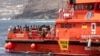 FILE - Para migran turun di pelabuhan "La Estaca" di Valverde di pulau Canary El Hierro, Spanyol, Senin, 26 Agustus 2024. Para migran tiba dengan perahu setelah pelayaran tiga belas hari dari pantai Senegal. (Maria Ximena/AP)