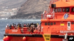 FILE - Migrants disembark at the port of on 'La Estaca' in Valverde at the Canary island of El Hierro, Spain, Aug. 26, 2024. Rescue teams on Sunday resumed searching for at least 48 migrants who went messing the day before when their boat overturned.