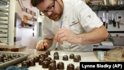 A chef in Miami, Florida puts some color onto freshly made bonbons, with chocolate made from cacao beans from Venezuela.