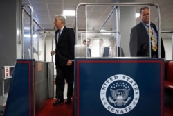 Senate Majority Leader Mitch McConnell of Ky., left, boards a subway car on Capitol Hill in Washington, Wednesday, March 18, 2020, before a vote on a coronavirus response bill.