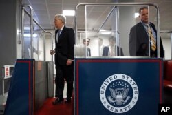 Senate Majority Leader Mitch McConnell of Ky., left, boards a subway car on Capitol Hill in Washington, Wednesday, March 18, 2020, before a vote on a coronavirus response bill.