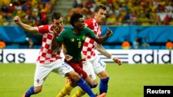 Darijo Srna (G) et Mario Mandzukic de la Croatie lutte pour le ballon avec Benjamin Moukandjo du Cameroun lors de leur match du Groupe A en Coupe du monde 2014 de football à l'aréna Amazonie à Manaus le 18 Juin, 2014 REUTERS / Murad Sezer. 