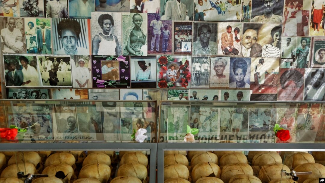 Flowers are laid on top of a glass case containing the skulls of some of those who were slaughtered as they sought refuge in the church, next to photographs of some of them, kept as a memorial to the thousands killed in and around the Catholic church during the 1994 genocide.