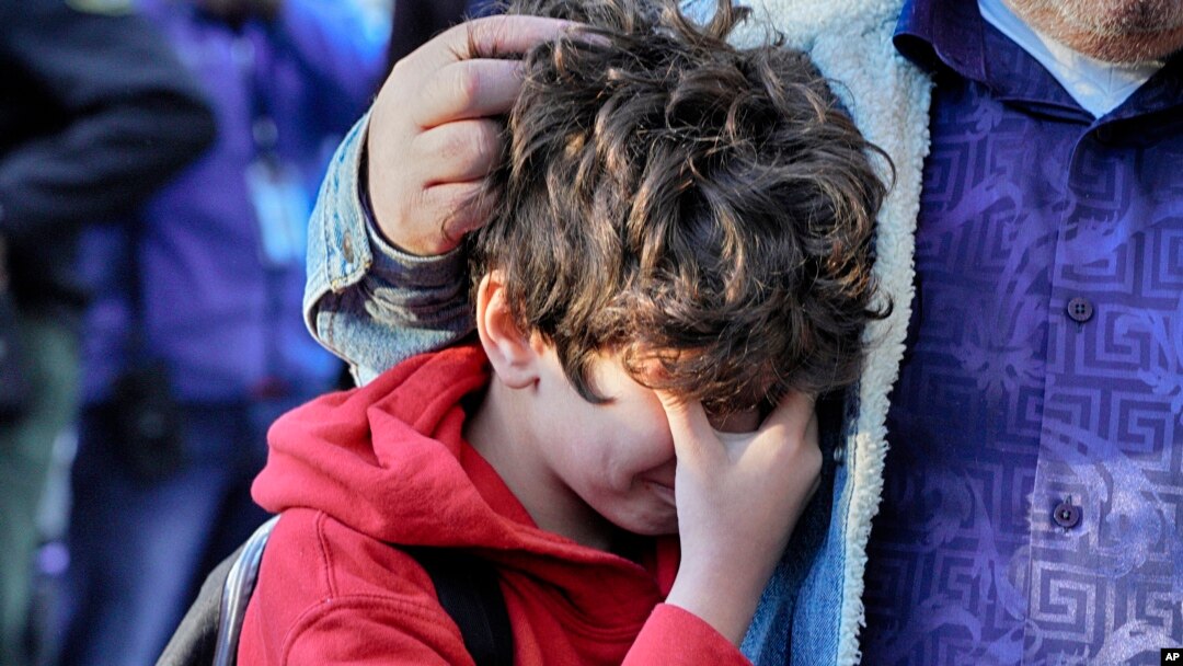 Palisades Charter Elementary School third grade student Jaden Koshki cries in his father's arm upon arriving at his new school, the Brentwood Elementary Science Magnet school in the Brentwood section of Los Angeles, Jan. 15, 2025.