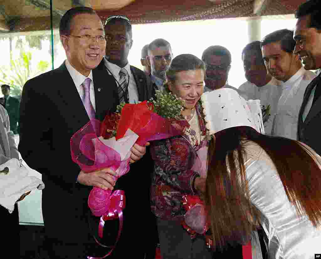 联合国秘书长潘基文(左)与夫人柳淳泽(中)2012年4月29日抵达下榻仰光的酒店时收到酒店工作人员送来的鲜花。