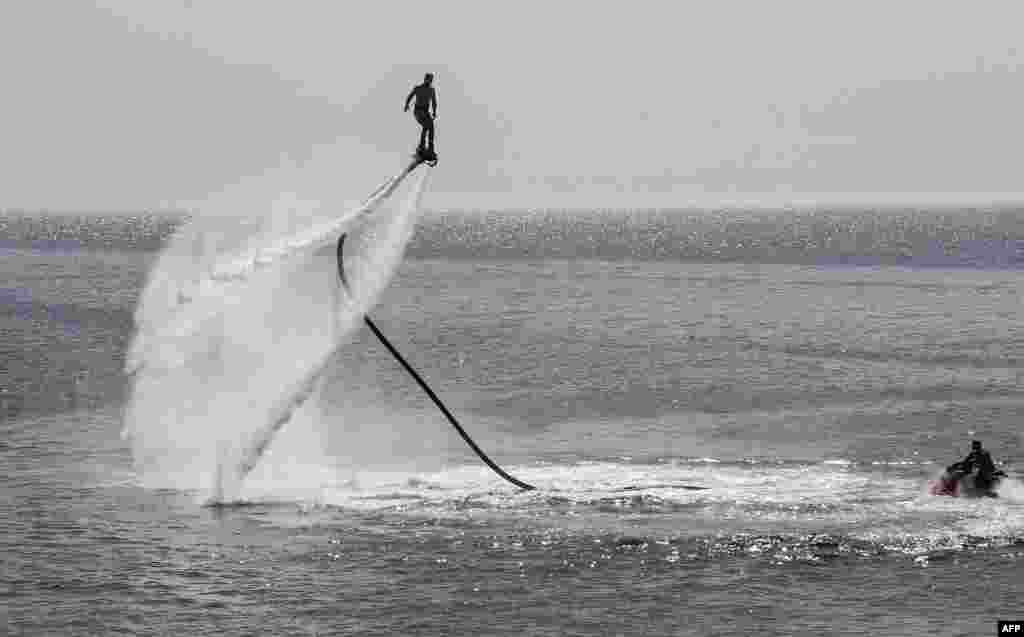 A Libyan rides an electric surfboard in the Mediterranean sea in the capital Tripoli, July 5, 2019.