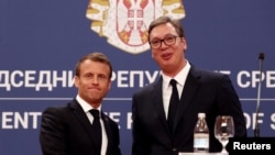 French President Emmanuel Macron and Serbian President Aleksandar Vucic shake hands after a joint news conference at the Serbia Palace building in Belgrade, Serbia, July 15, 2019. 