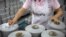 A worker packages spools of cotton yarn at a Huafu Fashion plant, as seen during a government organized trip for foreign journalists, in Aksu in western China's Xinjiang Uyghur Autonomous Region, April 20, 2021.