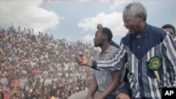 Then-African National Congress President Nelson Mandela salutes the crowd in February 1994. 