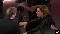 Fernanda Torres, a la derecha, felicita a Walter Salles tras ganar el premio por "Todavía Estoy Aquí", de Brasil, a mejor largometraje internacional durante los Oscar el 2 de marzo de 2025, en el Dolby Theatre de Los Ángeles.