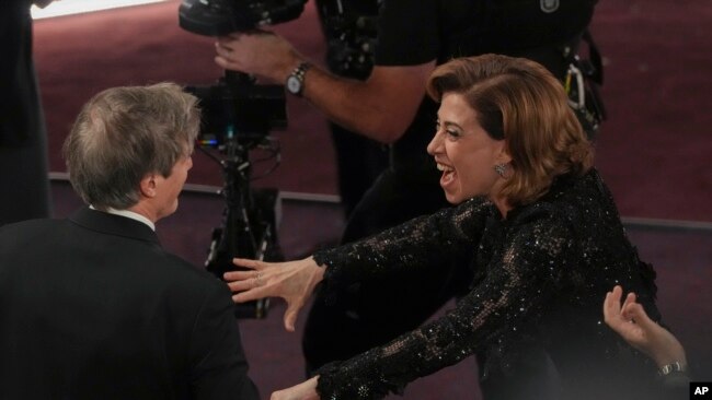 Fernanda Torres, a la derecha, felicita a Walter Salles tras ganar el premio por "Todavía Estoy Aquí", de Brasil, a mejor largometraje internacional durante los Oscar el 2 de marzo de 2025, en el Dolby Theatre de Los Ángeles.