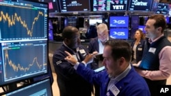 Specialist Genaro Saporito, foreground, works with traders at his post on the floor of the New York Stock Exchange, Sept. 18, 2024. 