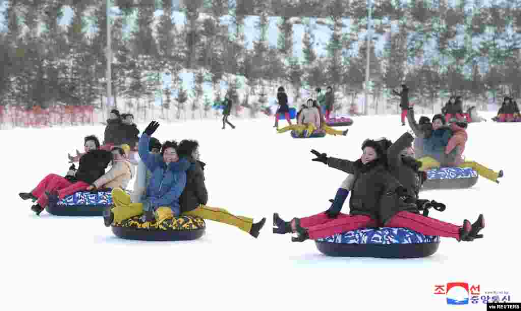 People play in the snow at the Yangdok Hot Spring Resort, North Korea, in this undated photo released by North Korea's Korean Central News Agency (KCNA).