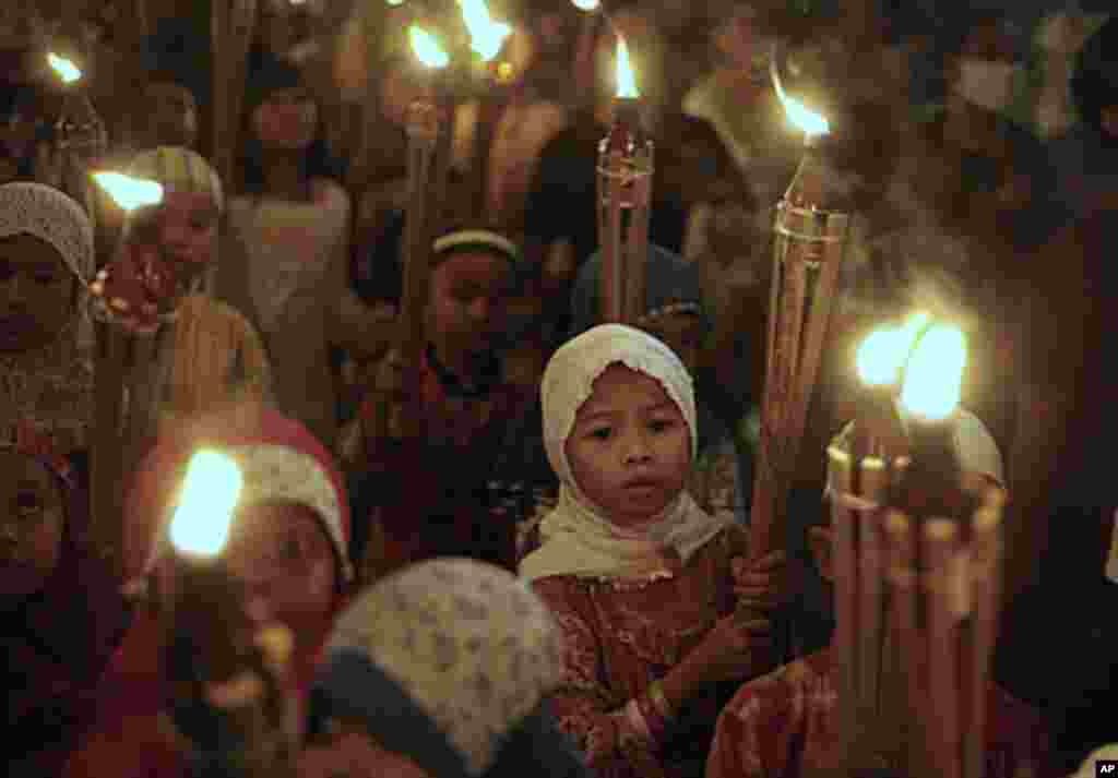 Indonesian Muslim children carry torches during a parade celebrating Eid al Fitr holiday that marks the end of the holy month of Ramadan in Jakarta, Indonesia, Aug. 30, 2011. AP