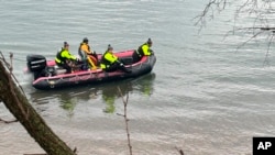 Miembros del Departamento de Bomberos de Alexandria buscan los restos del accidente cerca del Aeropuerto Nacional Ronald Reagan de Washington a lo largo del río Potomac en Alexandria, Virginia, el viernes 31 de enero de 2025.