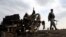 Afghan security forces gather at the site of Monday's attack near the Bagram Air Base, north of Kabul, Afghanistan, April 9, 2019.