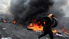 A demonstrator holds tires as he runs during a protest against Ecuador's President Lenin Moreno's austerity measures in Quito, Ecuador October 12, 2019. REUTERS/Ivan Alvarado