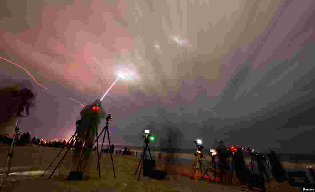 People watch as a Blue Origin New Glenn rocket lifts off on its inaugural launch at the Cape Canaveral Space Force Station in Cape Canaveral, Florida.