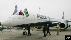 FILE - Azul airline official sprays champagne on company's first aircraft at the airport in Rio de Janeiro, Sept. 17, 2008. 