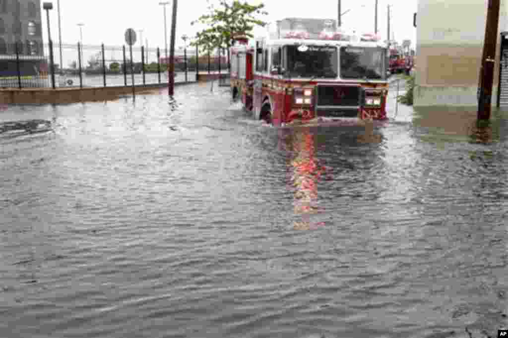 A fire truck drives through a flooded street in Brooklyn, New York, Sunday, Aug. 28, 2011. Seawater surged into the streets of Manhattan on Sunday as Tropical Storm Irene slammed into New York, downgraded from a hurricane but still unleashing furious win