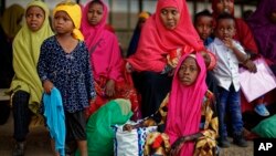 FILE - Some of around 20 Somali refugee families wait to be flown to Kismayo in Somalia, under a voluntary repatriation program, at the airstrip of Dadaab refugee camp in northern Kenya, Dec. 19, 2017.