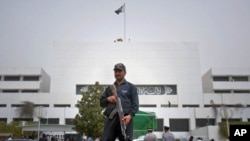 A Pakistani police commando stands guard at the parliament in Islamabad, Pakistan on, March 20, 2012. A special panel met Tuesday to discuss a review of tense relations with the United States. 